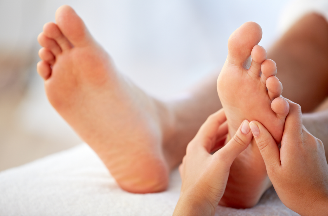 Reflexology treatment on one foot with both feet visible